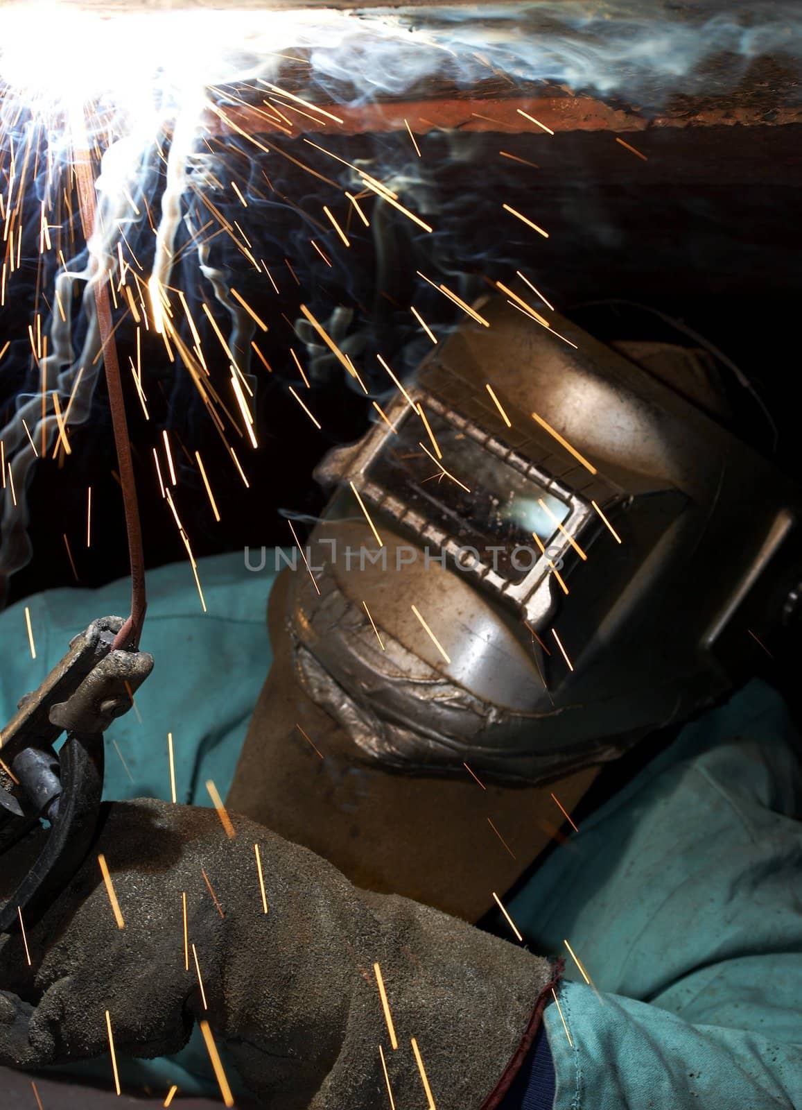 a welder working at shipyard under vessel