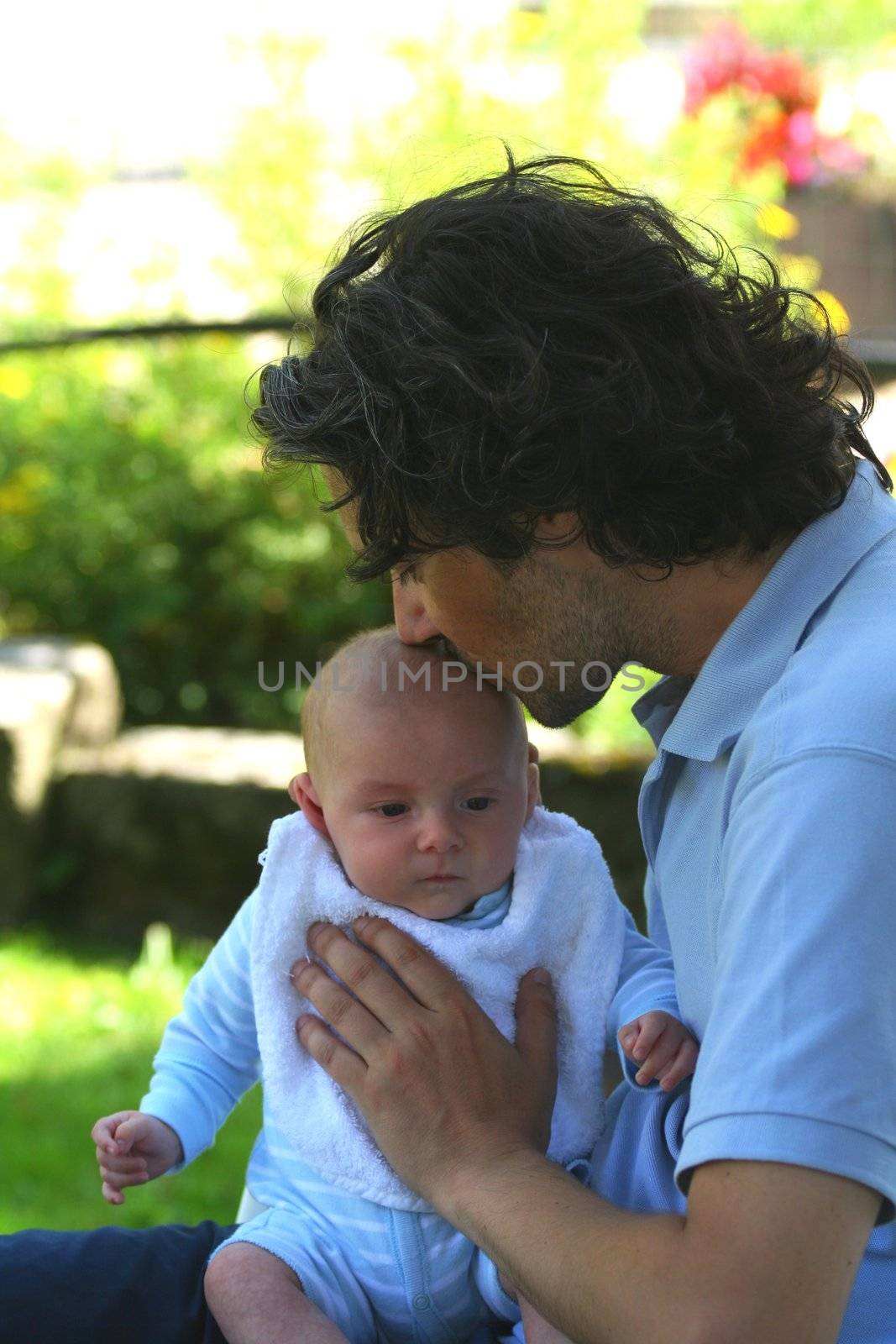 A father with his baby in his arms and kissed him on the head