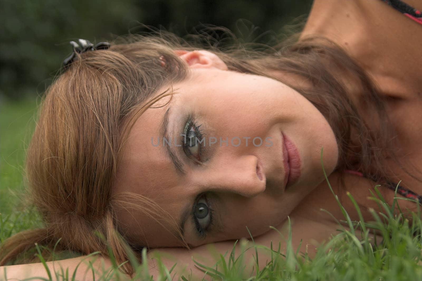 Head portrait of a pretty woman laying on the grass