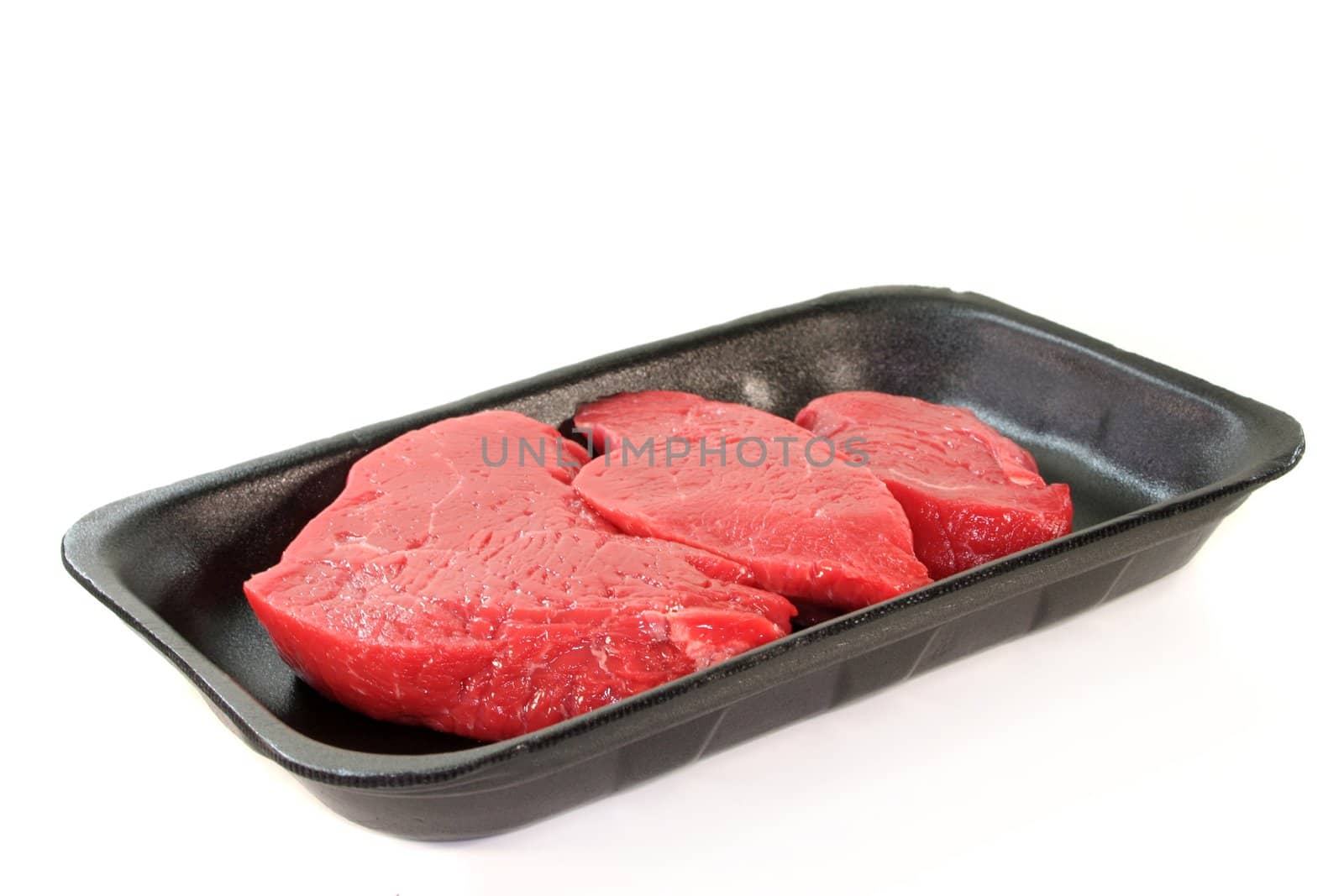 three raw beef rump steaks on a white background