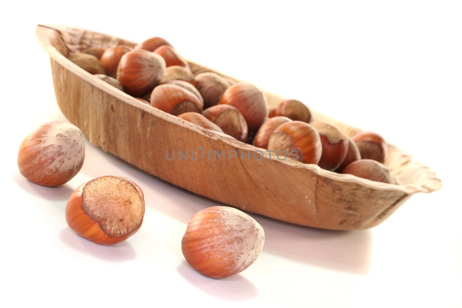 Hazelnuts in a bowl on a white background