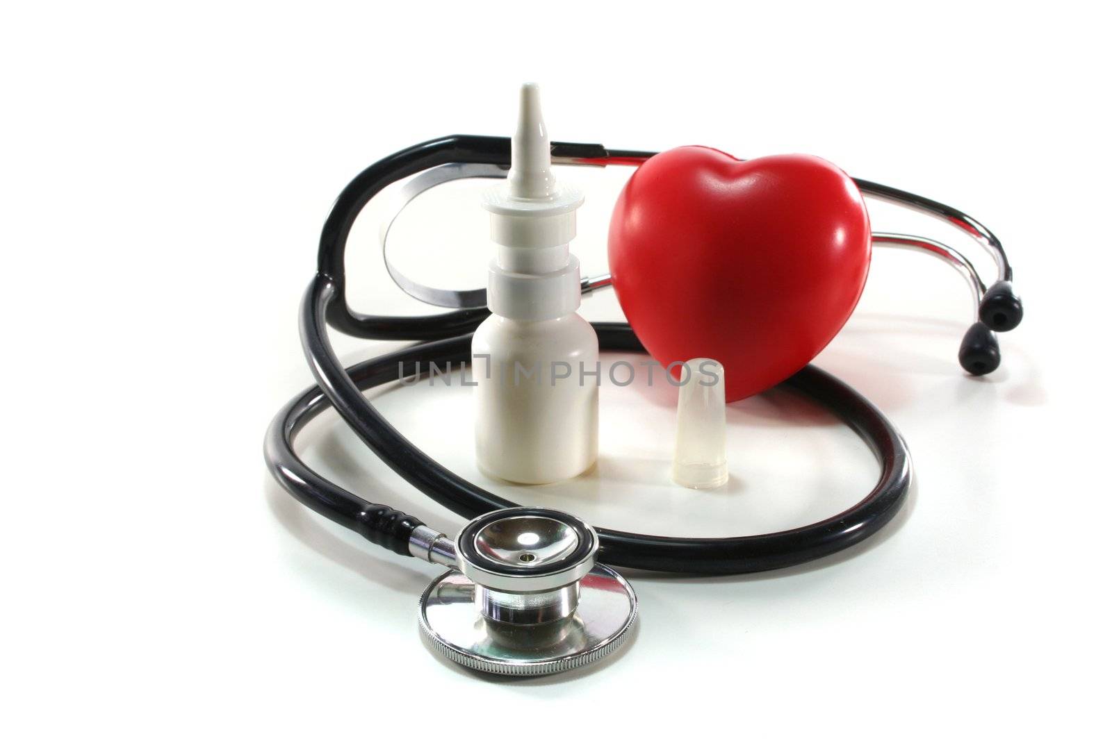 Stethoscope with heart and nasal spray on a white background