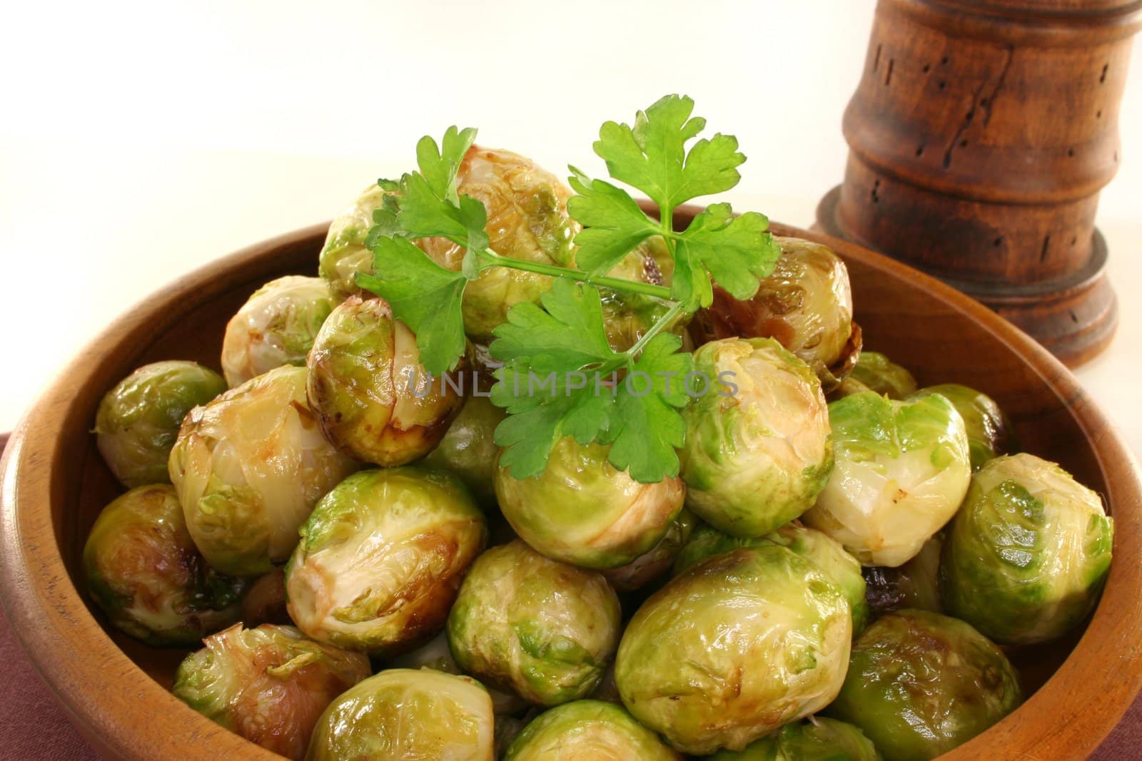 roasted brussels sprouts in a wooden bowl on a brown napkin