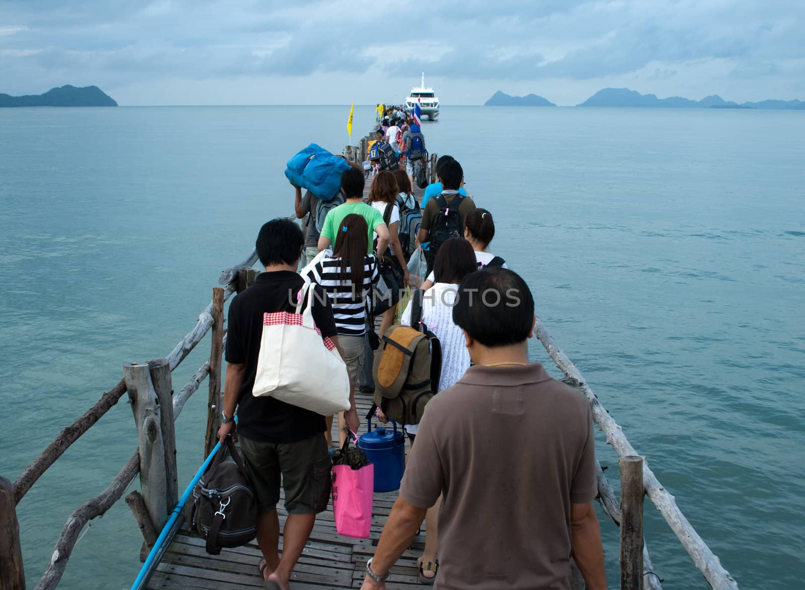 People going to boat on wooden pier at the sea side