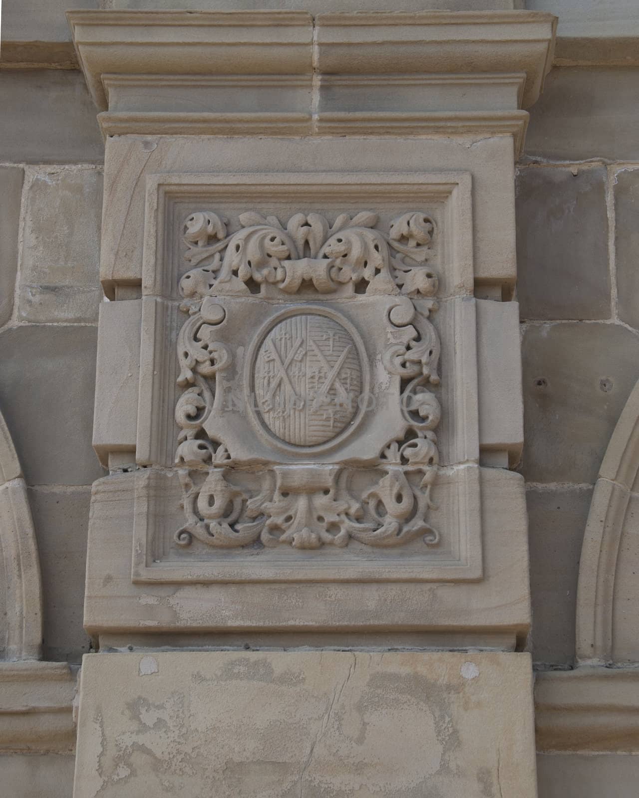 A carved stone plaque with a coat of arms