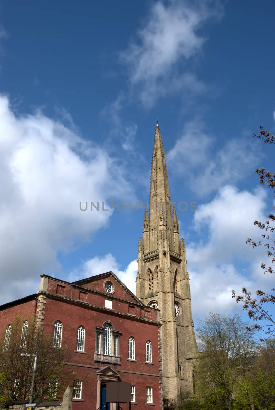 A red brick former chapel and a ruined church spire in Halifax Yorkshire