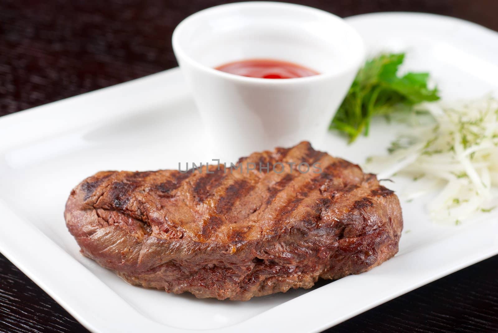 Juicy roasted beef steak with vegetables closeup at plate