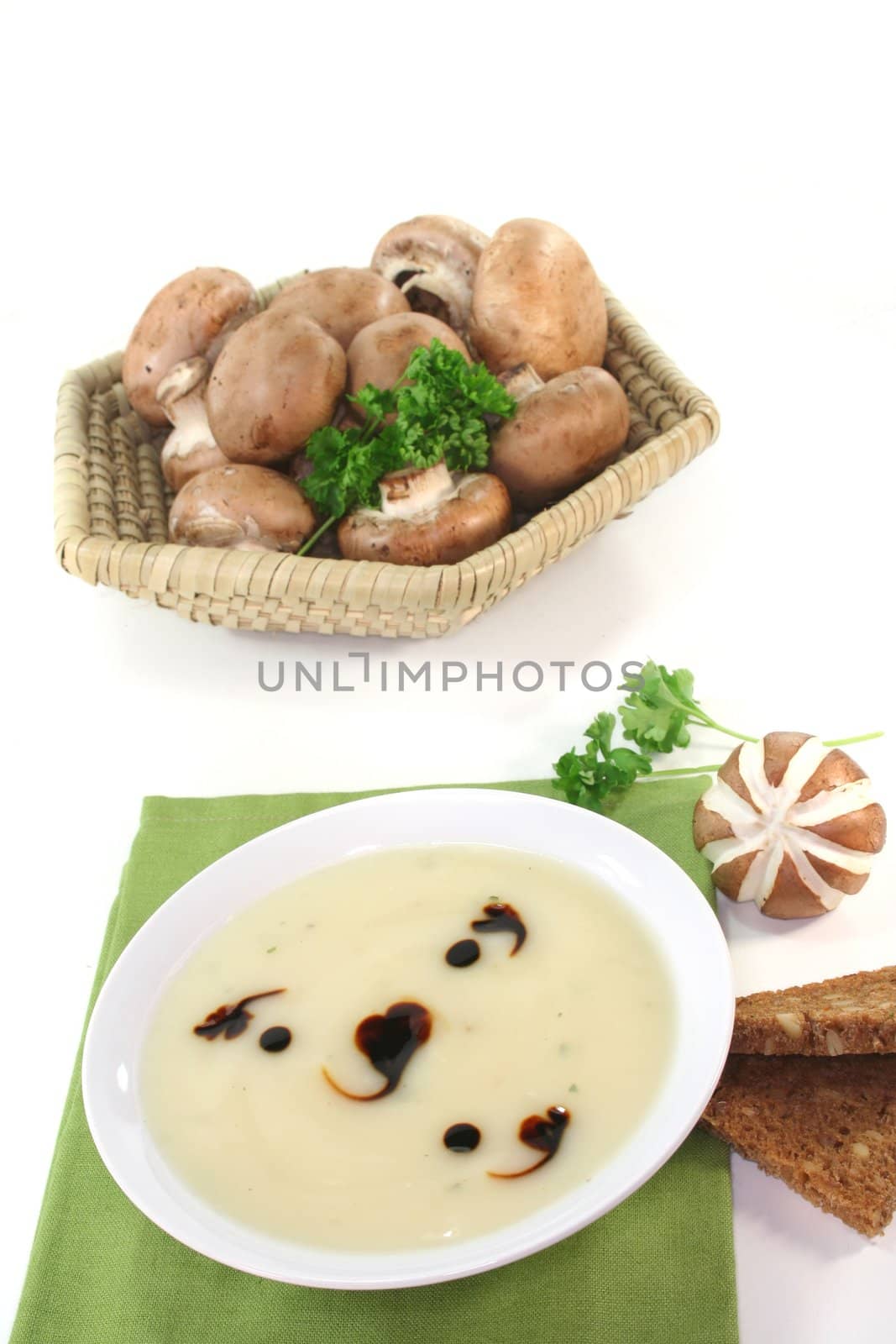 Cream of mushroom soup with fresh mushrooms, bread and parsley