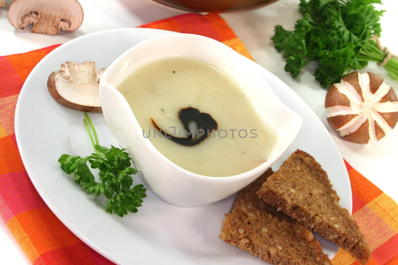 Cream of mushroom soup with fresh mushrooms, bread and parsley