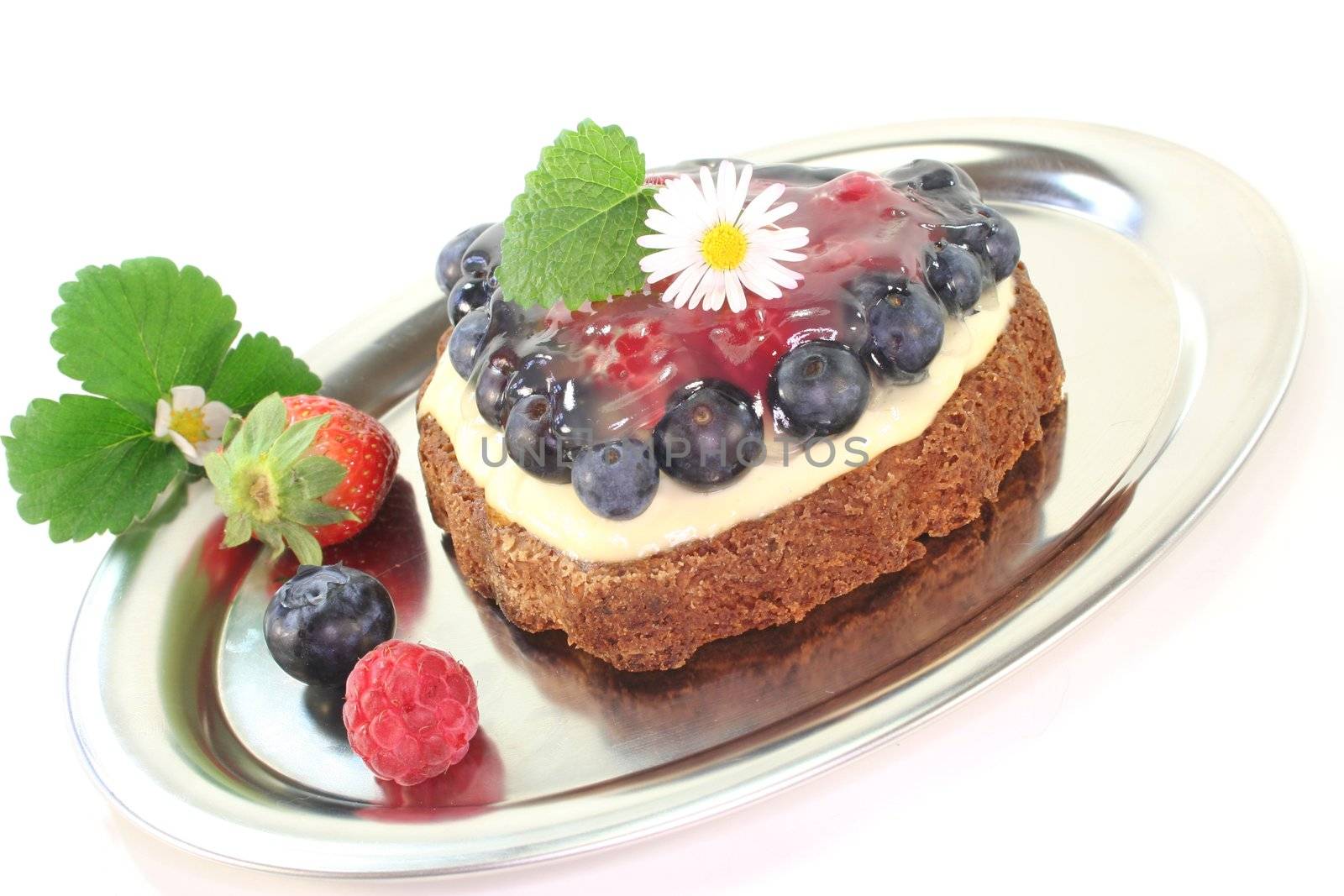 heart-shaped wild berry tart with berries, lemon balm and Daisy