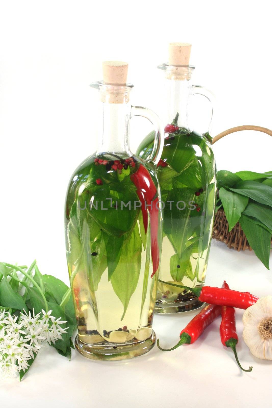 two bottles of Wild garlic oil with leaves and flowers on a white background