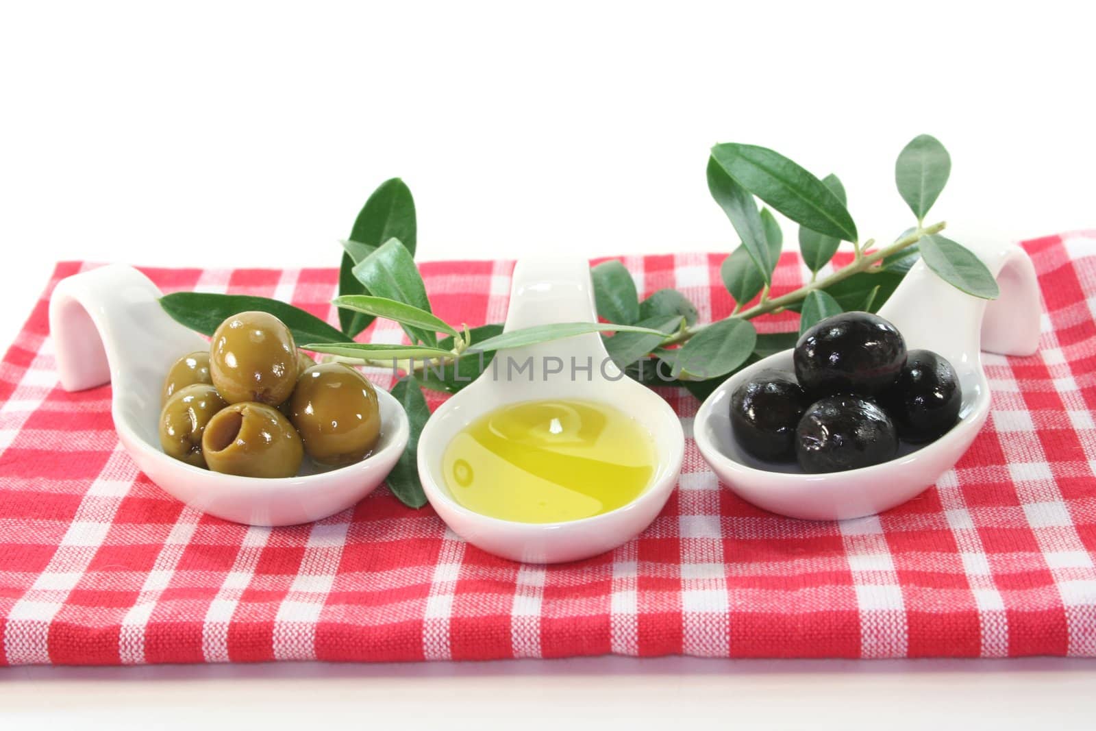 Olive oil with olives and olive branch served in bite spoons