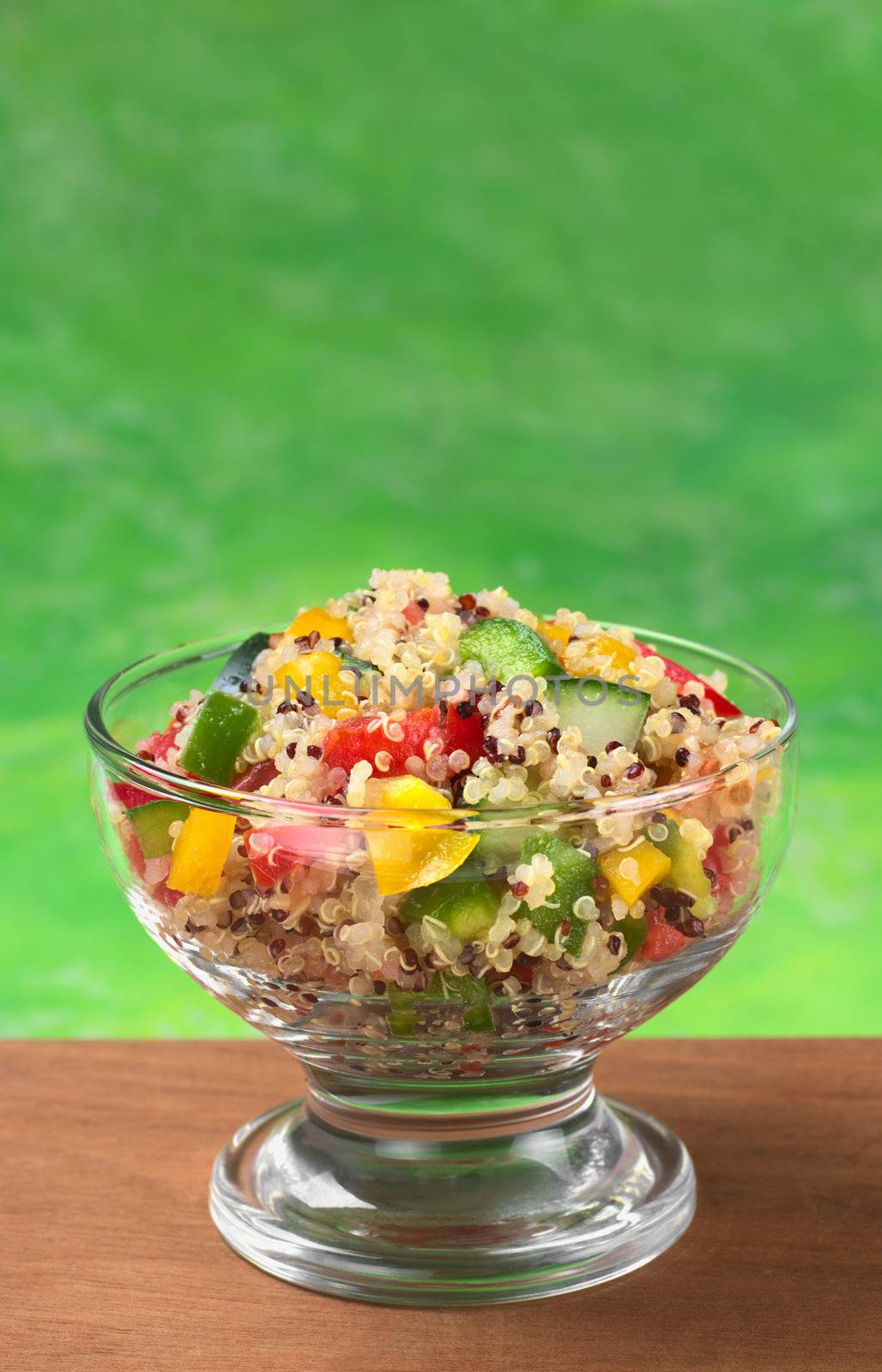 Delicious vegetarian quinoa salad with bell pepper, cucumber and tomatoes (Selective Focus, Focus on the salad in the front) 