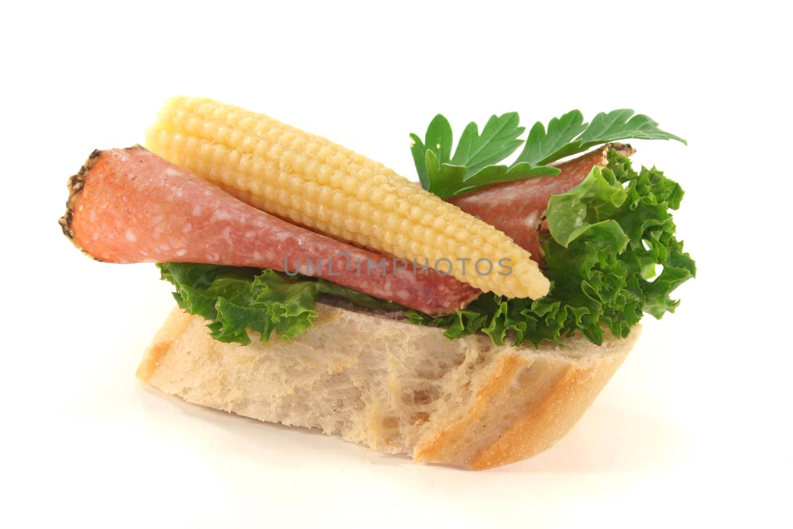 Canap� with lettuce, salami, corncob and parsley on a white background