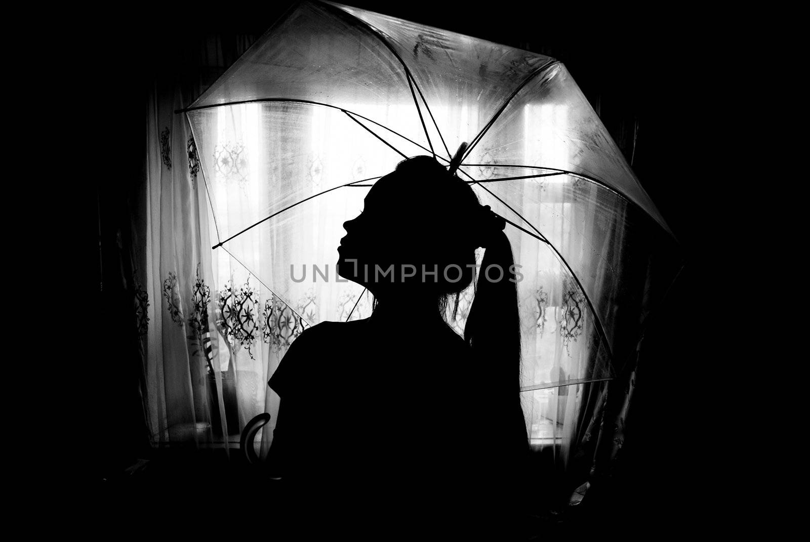 silhouette of a girl  with  an umbrella against the window