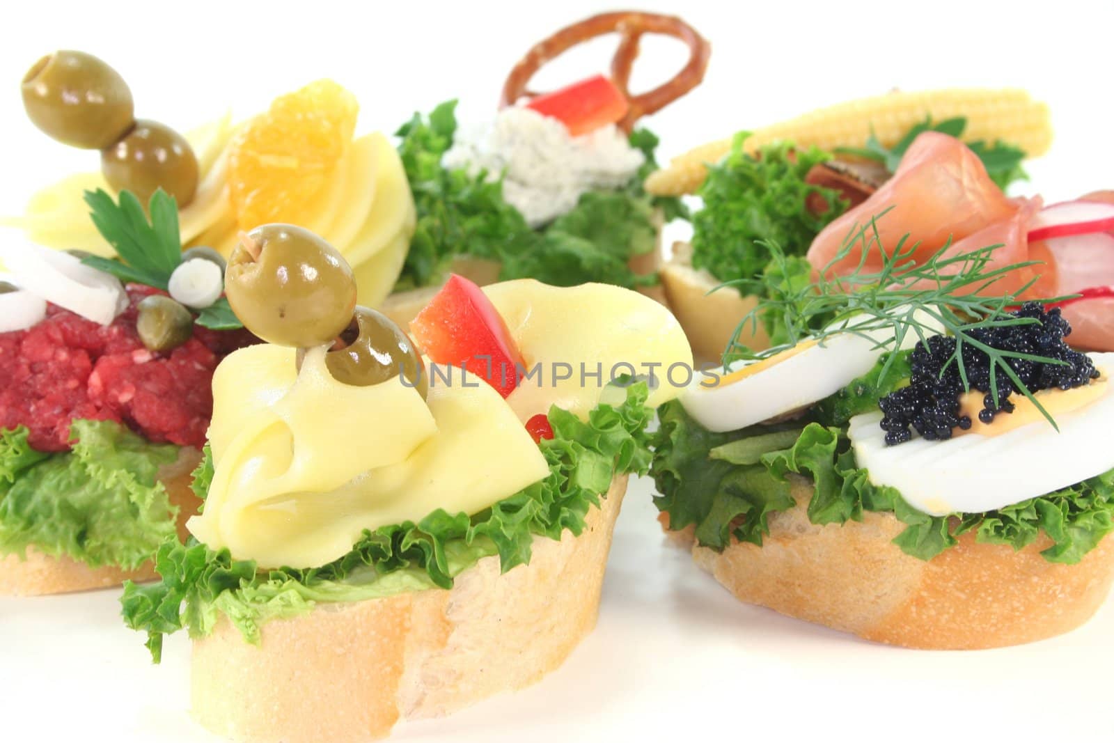 Canape with lettuce, cheese, sausage, cream cheese and eggs on a white background
