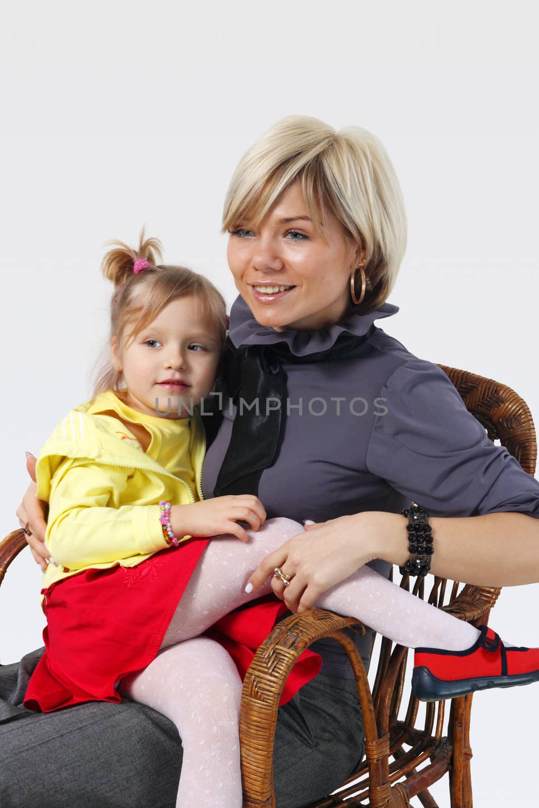 little girl hugs the young mother on the white background
