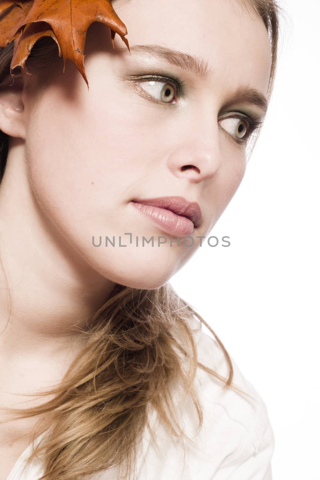 Portrait of a young woman with a autumn coloured leaf.