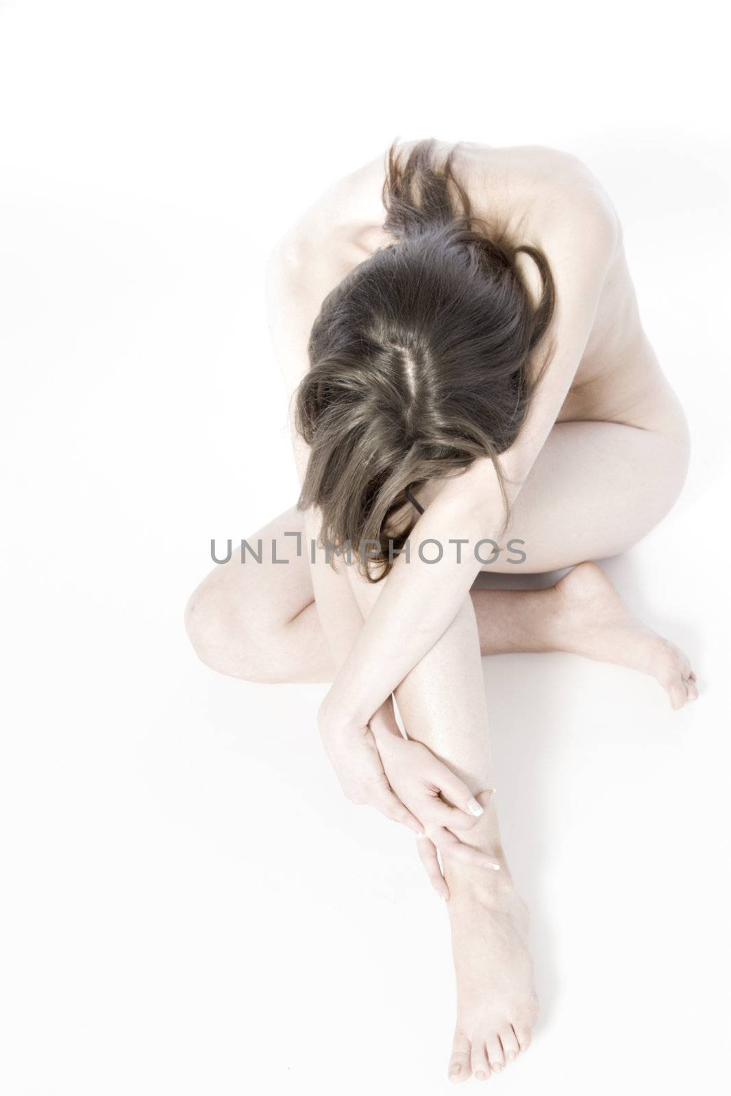 An artistic naked portrait of a woman cuddled up