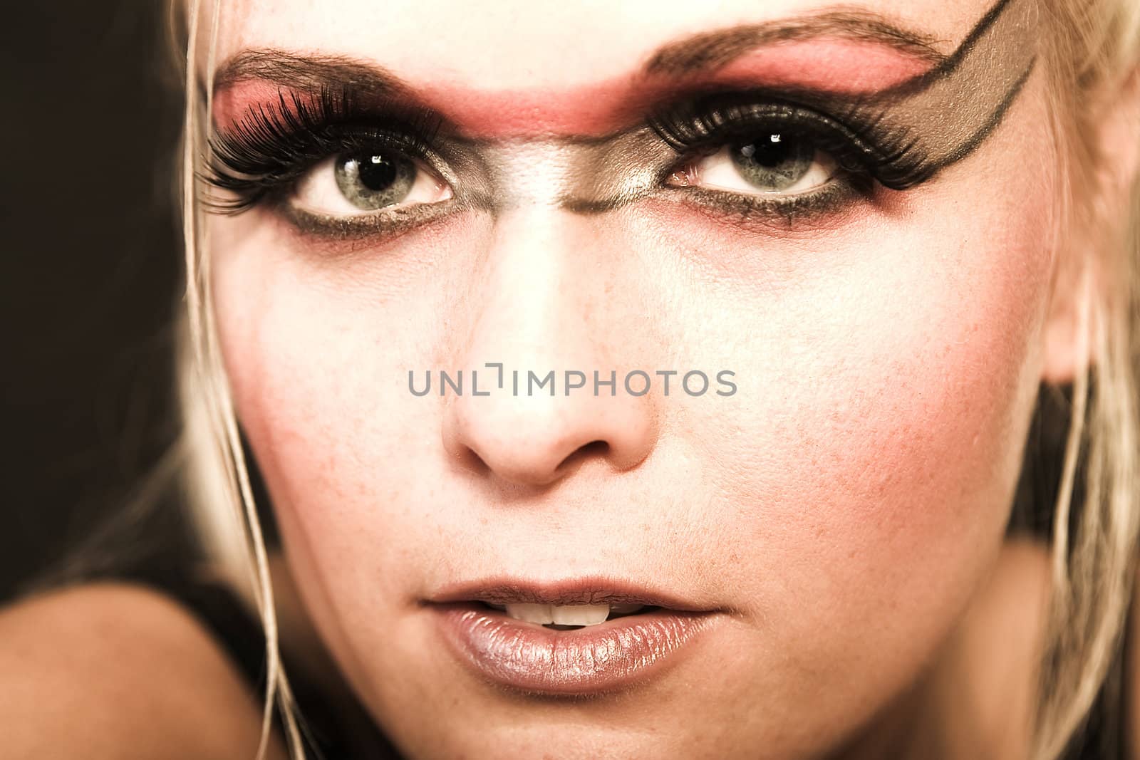 Portrait of a beautiful blond in the studio with extreme eye make-up