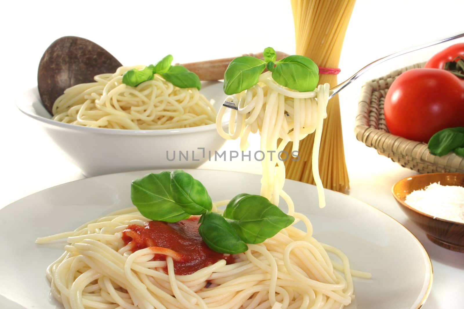 Spaghetti on a fork with tomato sauce and fresh basil