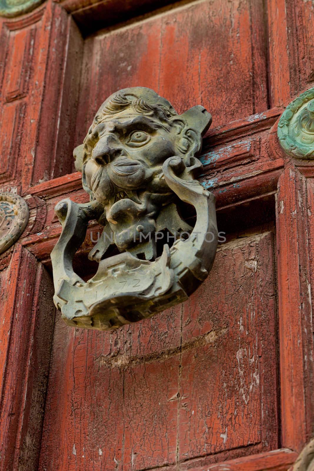 Detail of an ornate door knocker on the door of a building