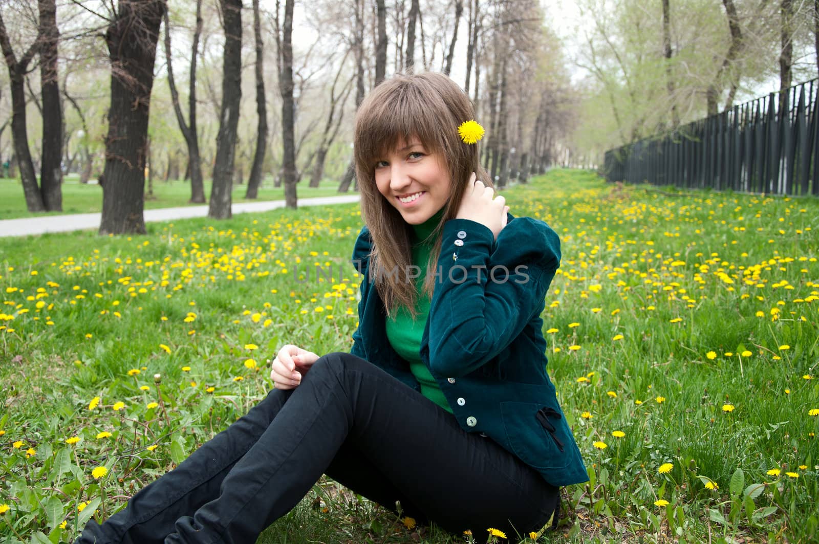 young girl in a park sitting on grass