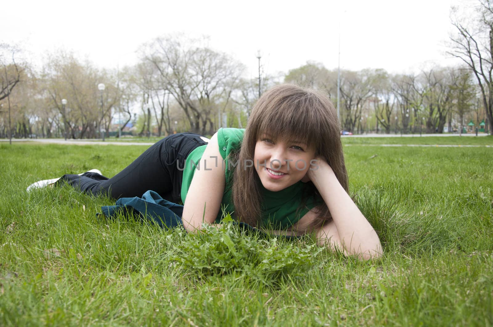 young girl lying on the grass in the park