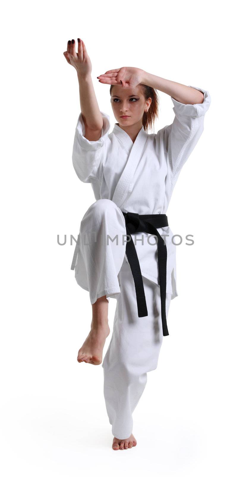 Karate. Young girl in a kimono with a white background
