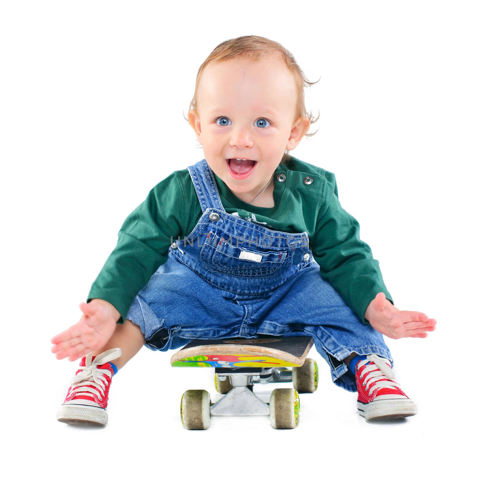 Cute 1 years old boy on a skateboard in the studio