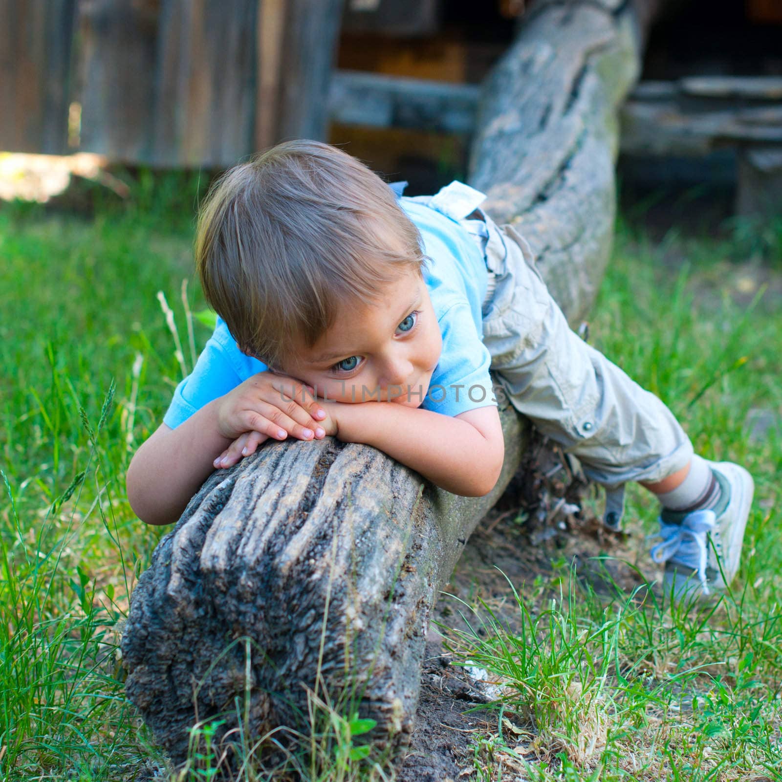 Cute 2 years old boy sitting on the the bench in the park