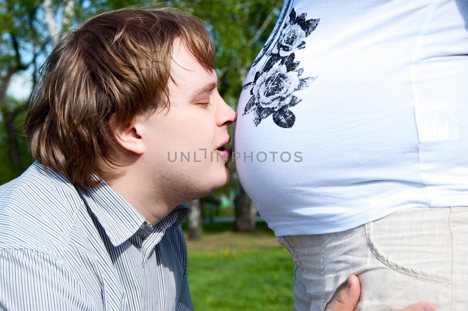 man kisses his wife's belly