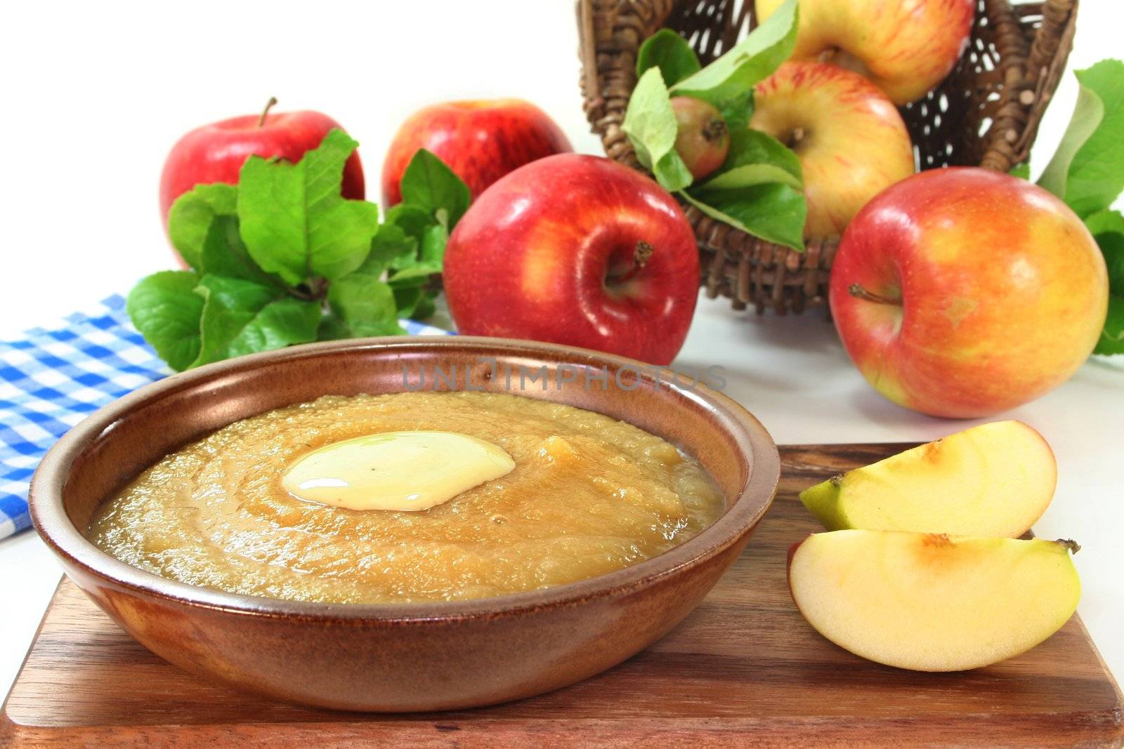 a bowl of applesauce with vanilla sauce and fresh apples