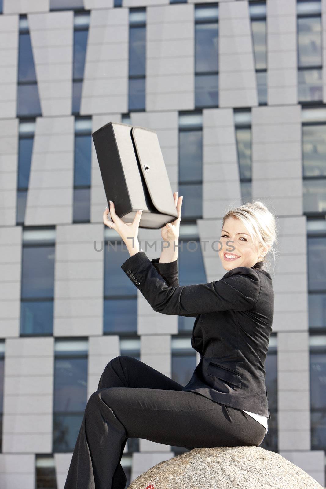 sitting young businesswoman with a briefcase by phbcz