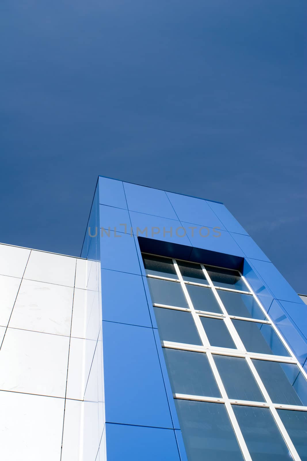 Morden office building facade against clear blue sky.