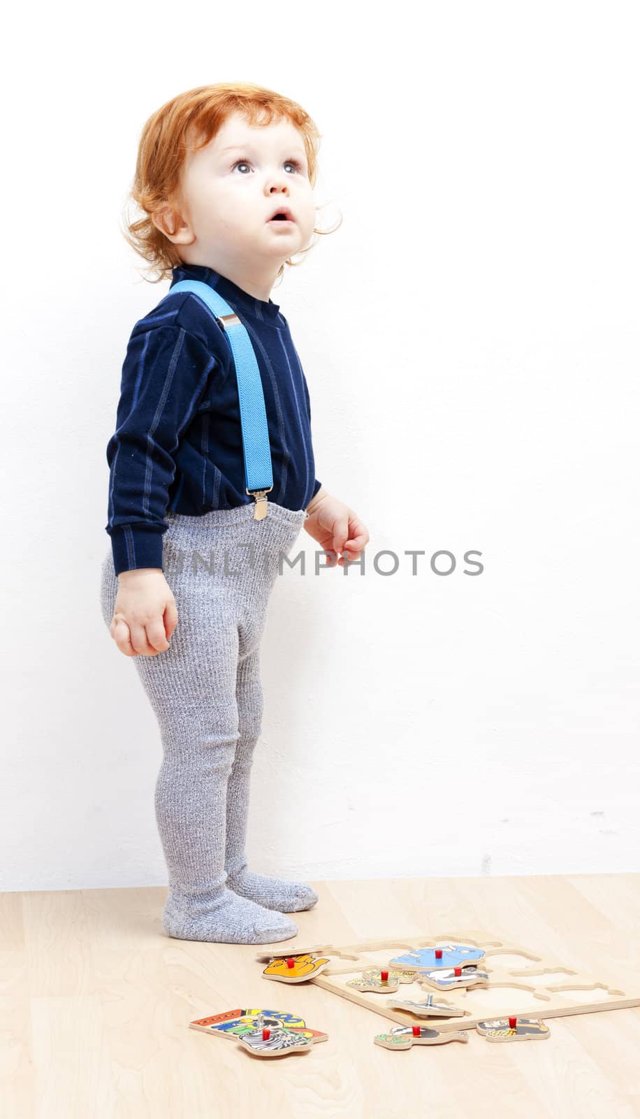 standing little boy with puzzle