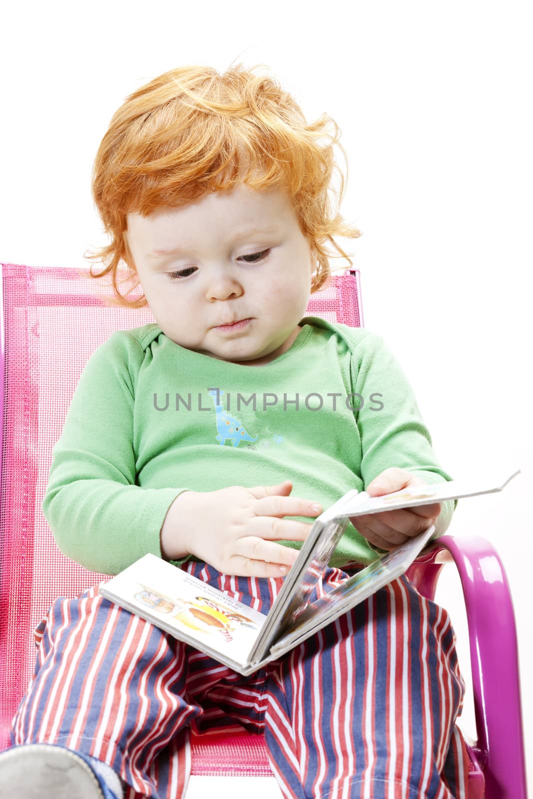 little boy with a book sitting on chair