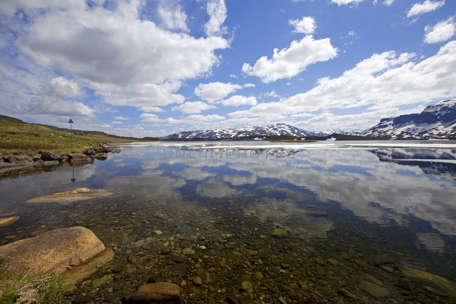 Snowcapped mountains reflecting in the water at Haukeli, Norway