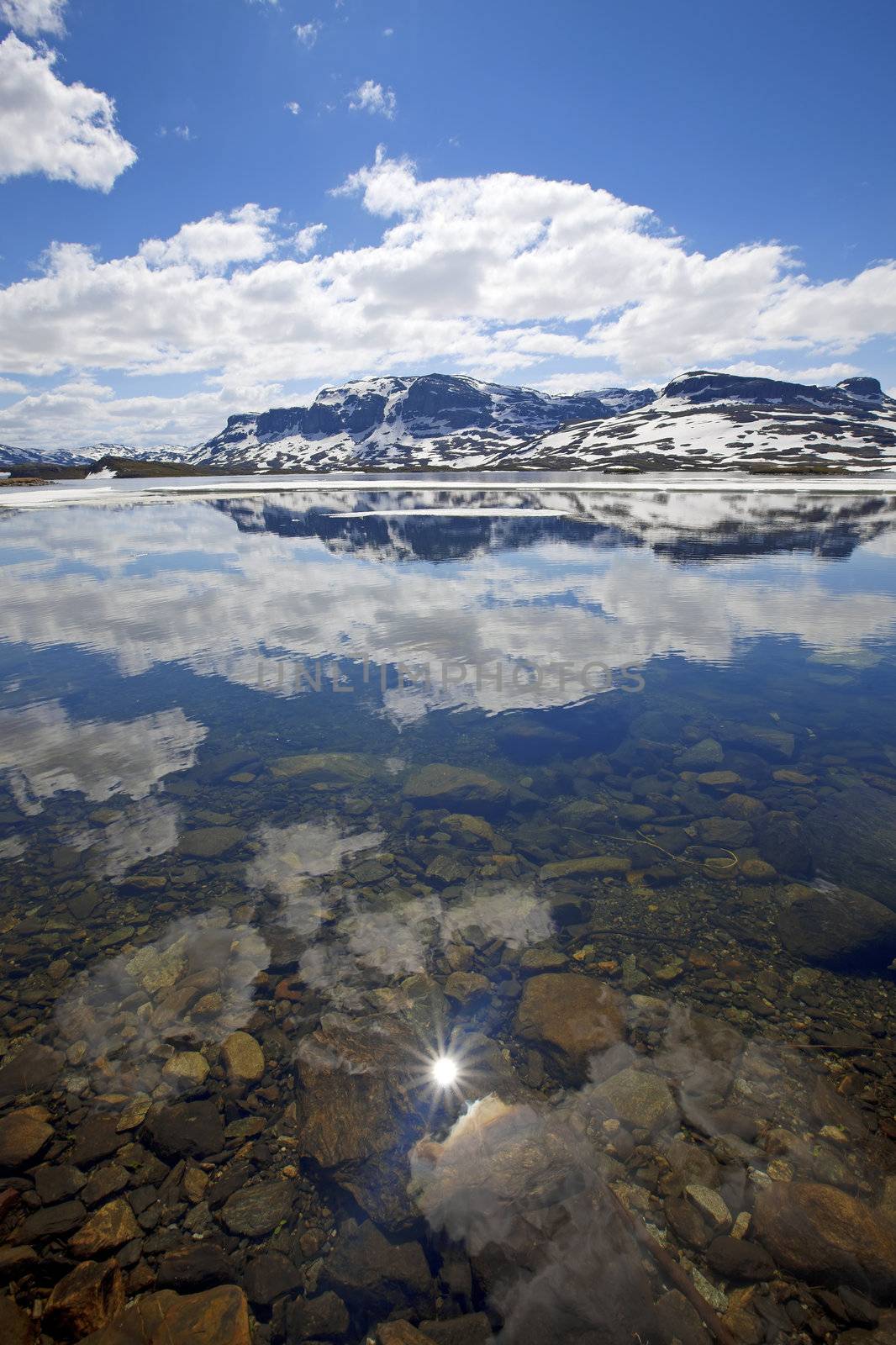 Snowcapped mountains reflecting in the water at Haukeli, Norway