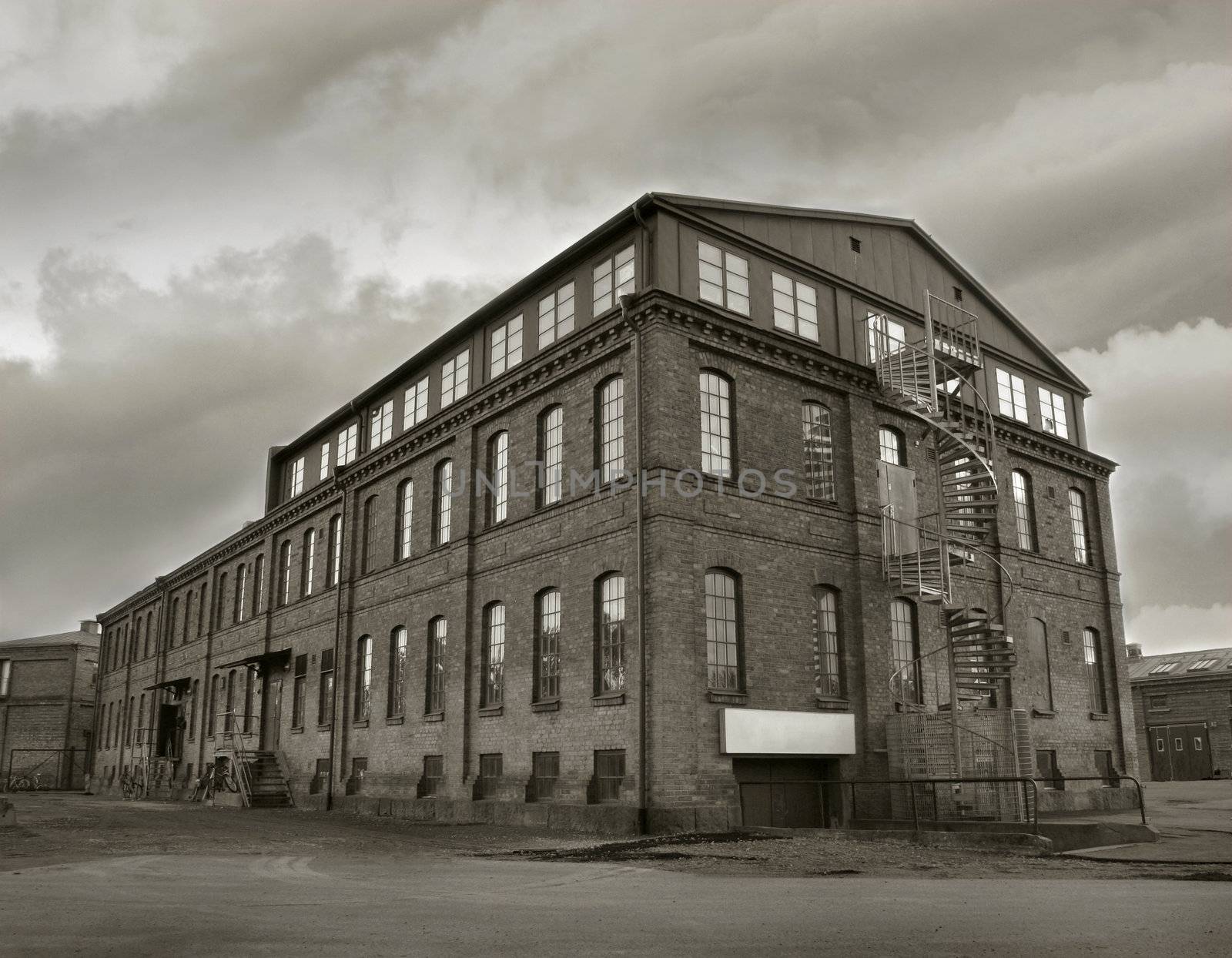 Old depressing factory building in sepia tone. Symbol for economic depressions.