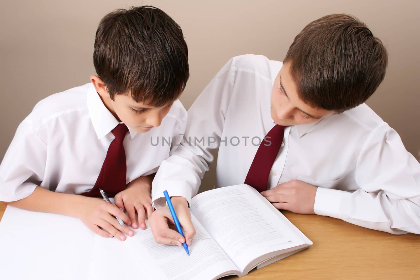 Teenage School boy busy with his homework, wearing uniform