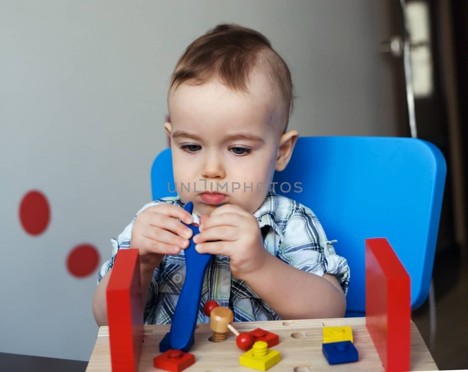 Little boy playing with wooden toy