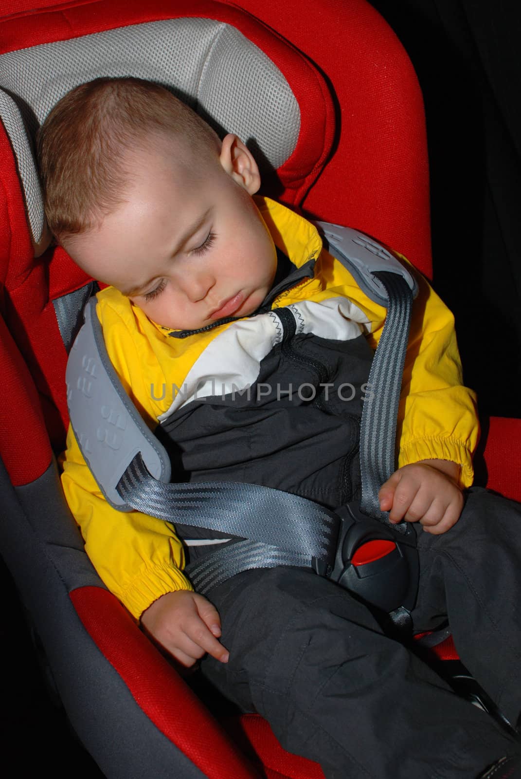 Boy one year old sleeping in car seat