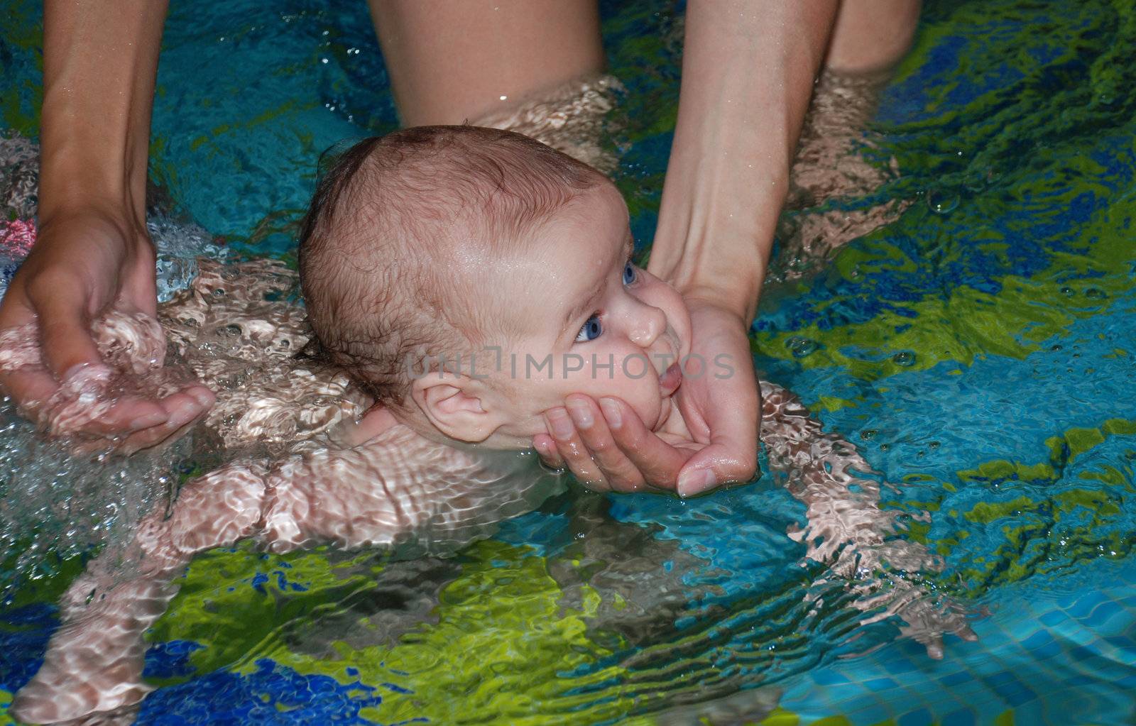 Teaching baby swimming in the pool