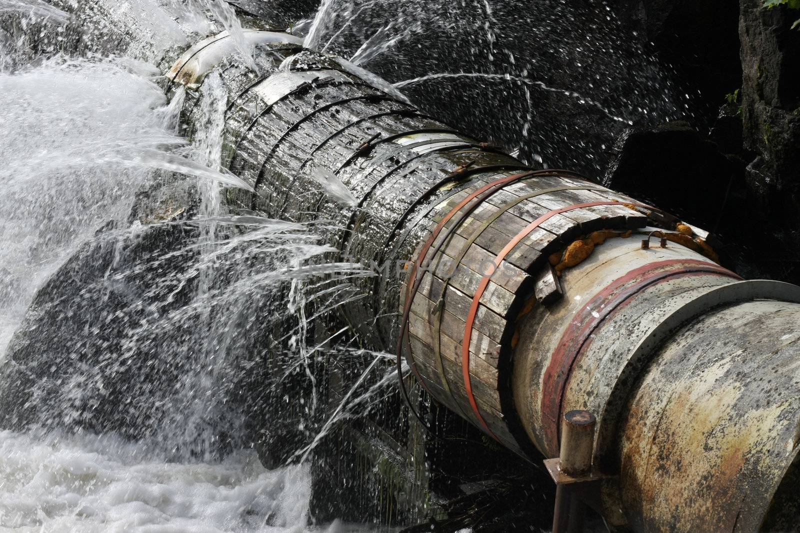 A broken pipe that leaks water in all directions.