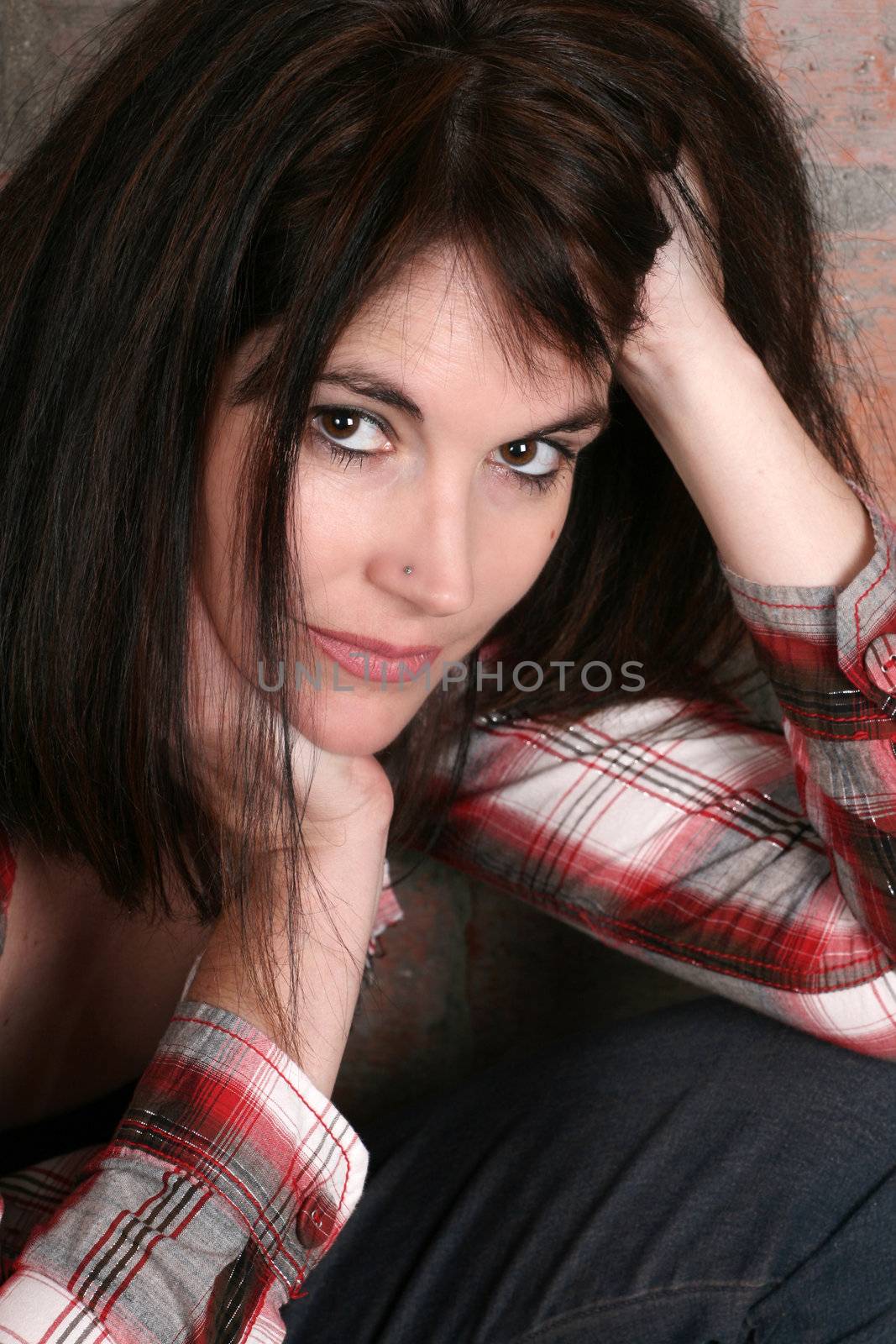 Beautiful brunette woman against a brick wall background