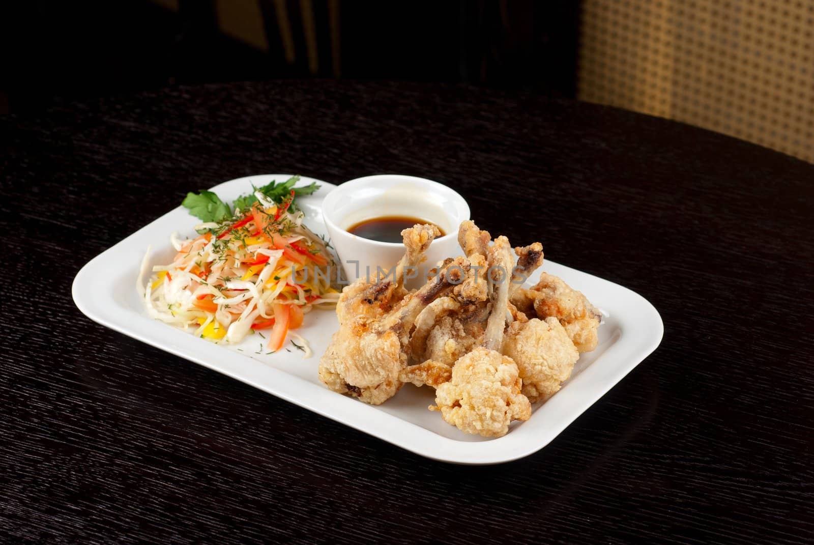 Fried chicken wings garnished with fresh vegetables with Teriyaki sauce