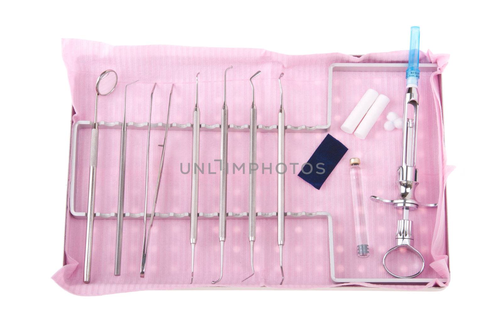 dentistry kit in a tray on pink bib (surgery instruments, articulation paper, cotton rolls/wools, cartridge and syringe)
