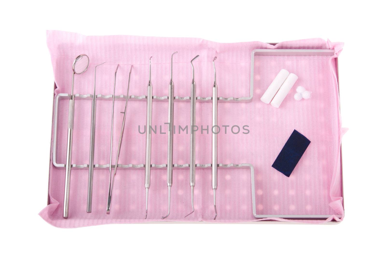 dentistry kit in a tray on pink bib (surgery instruments, articulation paper, cotton rolls and wools)