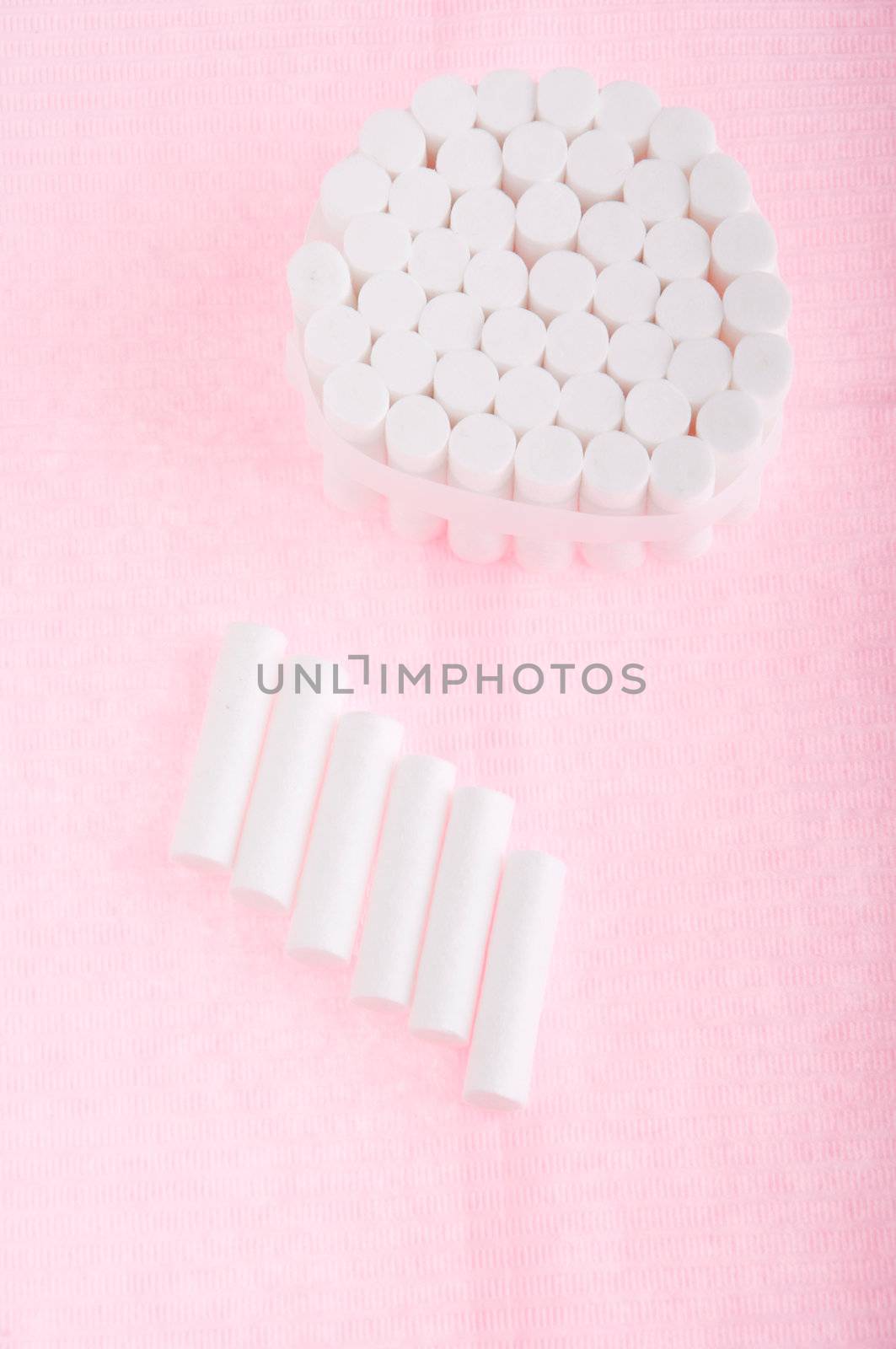 dental cotton rolls on a pink bib (dentistry equipment)